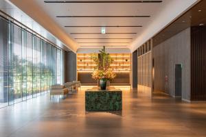 a lobby with a table with a plant on it at THE BLOSSOM HAKATA Premier in Fukuoka