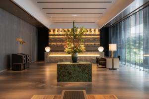 a lobby with a vase of flowers on a table at THE BLOSSOM HAKATA Premier in Fukuoka