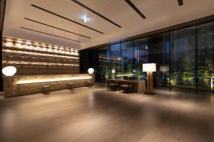 a lobby of a building with a desk and large windows at THE BLOSSOM HAKATA Premier in Fukuoka