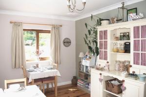 a kitchen with a table and a dining room at Innisfree Cottage in Eyam