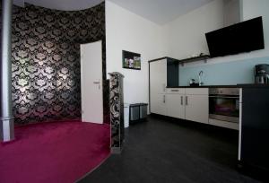 a living room with a pink carpet and a tv at Faupel Ferienwohnung in Mülverstedt
