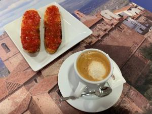 Deux morceaux de nourriture et une tasse de café sur une table dans l'établissement Casa Rural Magnanimvs, à Vilafamés