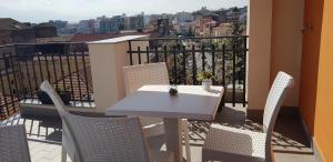 uma mesa branca e cadeiras numa varanda em Albergo Milazzo Inn AiMori em Milazzo