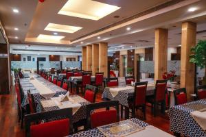 a dining room with tables and chairs in a restaurant at Hotel Airport Residency in New Delhi