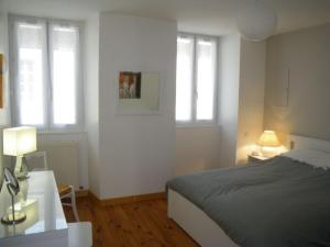 um quarto com uma cama e duas janelas em La Galerie Privée em Pontcharra