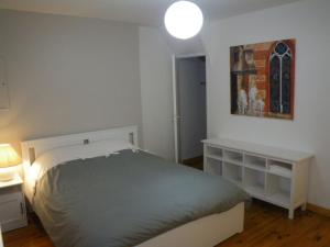1 dormitorio con 1 cama, 1 mesa y 1 pintura en La Galerie Privée, en Pontcharra