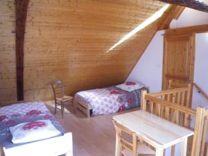 Zimmer mit 2 Betten und einem Tisch im Dachgeschoss in der Unterkunft La Galerie Privée in Pontcharra