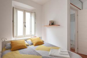a bedroom with a bed with yellow pillows and a window at Appartamento 121 in Prato