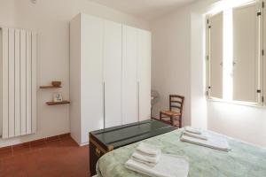 a bedroom with a bed and a mirror and a chair at Appartamento 122 in Prato