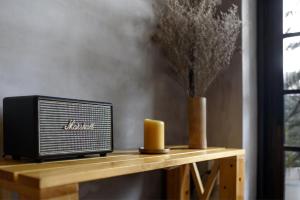 a radio sitting on a wooden table with a candle at CIRCADIAN Industrial Loft In Heritage Building in Ho Chi Minh City