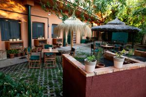 an outdoor patio with tables and chairs and umbrellas at Hostel Layos, Toledo in Layos