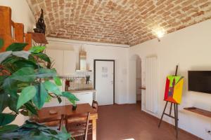 een keuken en eetkamer met een bakstenen plafond bij Appartamento 123 in Prato