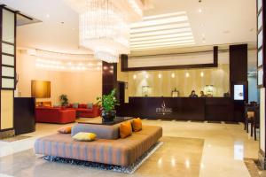 a lobby with a couch in the middle of a room at City Seasons Hotel & Suites Muscat in Muscat