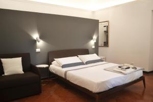 a bedroom with a bed and a black chair at Da Domè Charm Rooms in Levanto