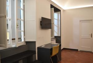 a room with a desk and a tv on a wall at Da Domè Charm Rooms in Levanto +17 photos
