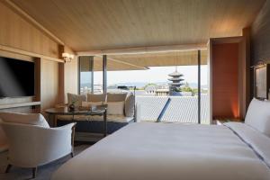 a hotel room with a bed and a balcony at Park Hyatt Kyoto in Kyoto