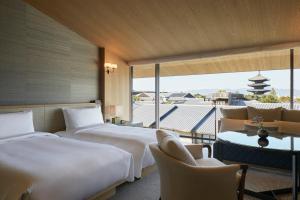 a hotel room with two beds and a balcony at Park Hyatt Kyoto in Kyoto