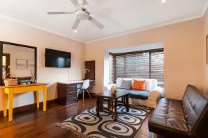 a living room with a couch and a table at Africa Beach B&B in Port Elizabeth