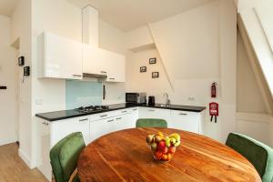 eine Küche mit einem Holztisch und einer Obstschale in der Unterkunft Stayci Serviced Apartments Central Station in Den Haag