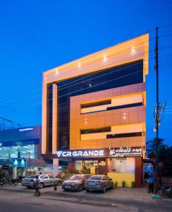 ein großes Gebäude mit davor geparkt in der Unterkunft CR Grande in Madurai