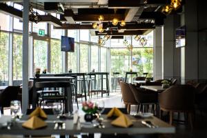 a dining room with tables and chairs and windows at Signature 1 Hotel Tecom in Dubai