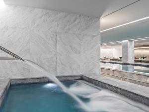 a bath room with a tub and a pool at Grand Hyatt Athens in Athens