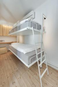 a white bunk bed in a room with a wooden floor at Amazing Apartment in Downtown Maribor in Maribor