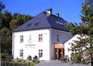 a white building with a black roof at Hotel pod Kapličkou in Malá Morávka