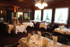 un comedor con mesas con manteles blancos en Hotel Bramen, en Kloten