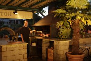 a man standing in front of a grill cooking food at Hotel Bramen in Kloten