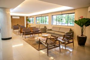 a waiting room with chairs and a couch and tables at Atrium Confort Hotels in Parauapebas