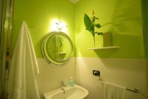 zieloną łazienkę z umywalką i lustrem. w obiekcie Casa Decò Business Stay Solution w mieście Tarent +25 zdjęć