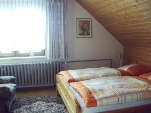 sypialnia z 2 łóżkami i oknem w obiekcie Ferienwohnung Peter Engelhardt w mieście Schmiedefeld am Rennsteig