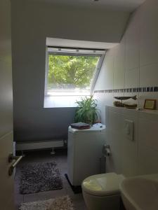 a bathroom with a toilet and a window at Stadtnahe Unterkunft im Grünen in Berlin