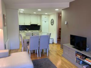 a living room with a table and chairs and a kitchen at El Estacho de Panticosa in Panticosa