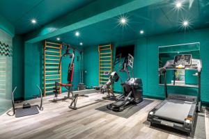 a gym with blue walls and tread machines at Best Western Hôtel Grand Parc Marne La Vallée in Chanteloup-en-Brie +25 photos