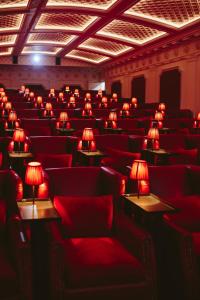 een kamer met rode stoelen en tafels met lampen erop bij The Scotsman Hotel in Edinburgh