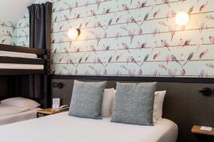 a bedroom with a bed and a wall with pink birds at Best Western Hôtel Grand Parc Marne La Vallée in Chanteloup-en-Brie