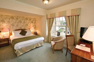 a hotel room with a bed and a television at Old Hunstanton Le Strange Arms Hotel in Hunstanton