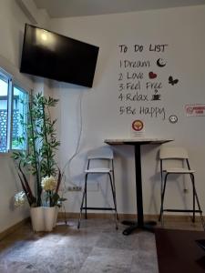 a table with two stools in a room with writing on the wall at Málaga Centro Hostel in Málaga