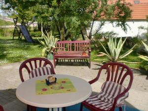 uma mesa e duas cadeiras e um banco rosa em Hotel & Restaurant "Zum Firstenstein" em Königshain