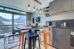 a kitchen with a bar with stools and a view at SCHUSS B4 in Morzine