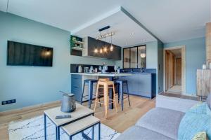 a kitchen and living room with blue walls at SCHUSS B4 in Morzine +7 photos