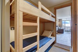 a bunk bed in a tiny house with a living room at SCHUSS B4 in Morzine