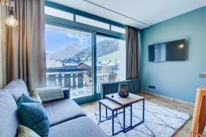 a living room with a couch and a large window at SCHUSS B4 in Morzine