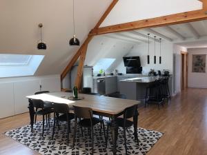 cocina y comedor con mesa de madera y sillas en Le Loft Deveney-Mars en Puligny-Montrachet