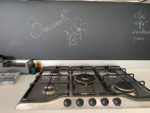 een oven met een kookplaat en een bloem aan de muur bij Villa Elma in Lonato