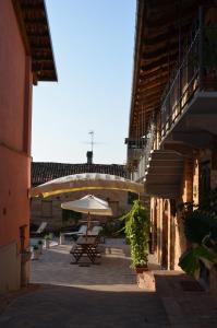 eine Terrasse mit einem Tisch und einem Sonnenschirm in der Unterkunft La Corte Di Gerardo in Tonco