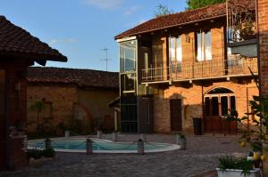 a building with a swimming pool in a courtyard at La Corte Di Gerardo in Tonco