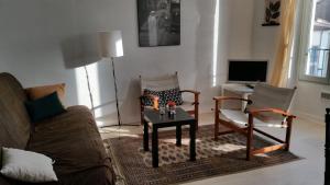 sala de estar con sofá, 2 sillas y mesa en Appartement centre historique Beziers, en Béziers